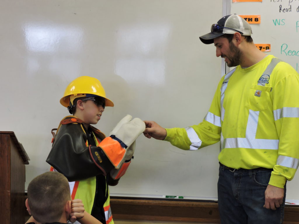 Jared Klein, electrical lineman, at Arlington school showing student tools