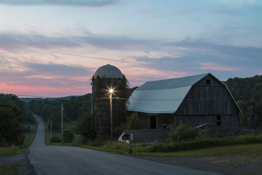 barn on farm property with a sunset in the background